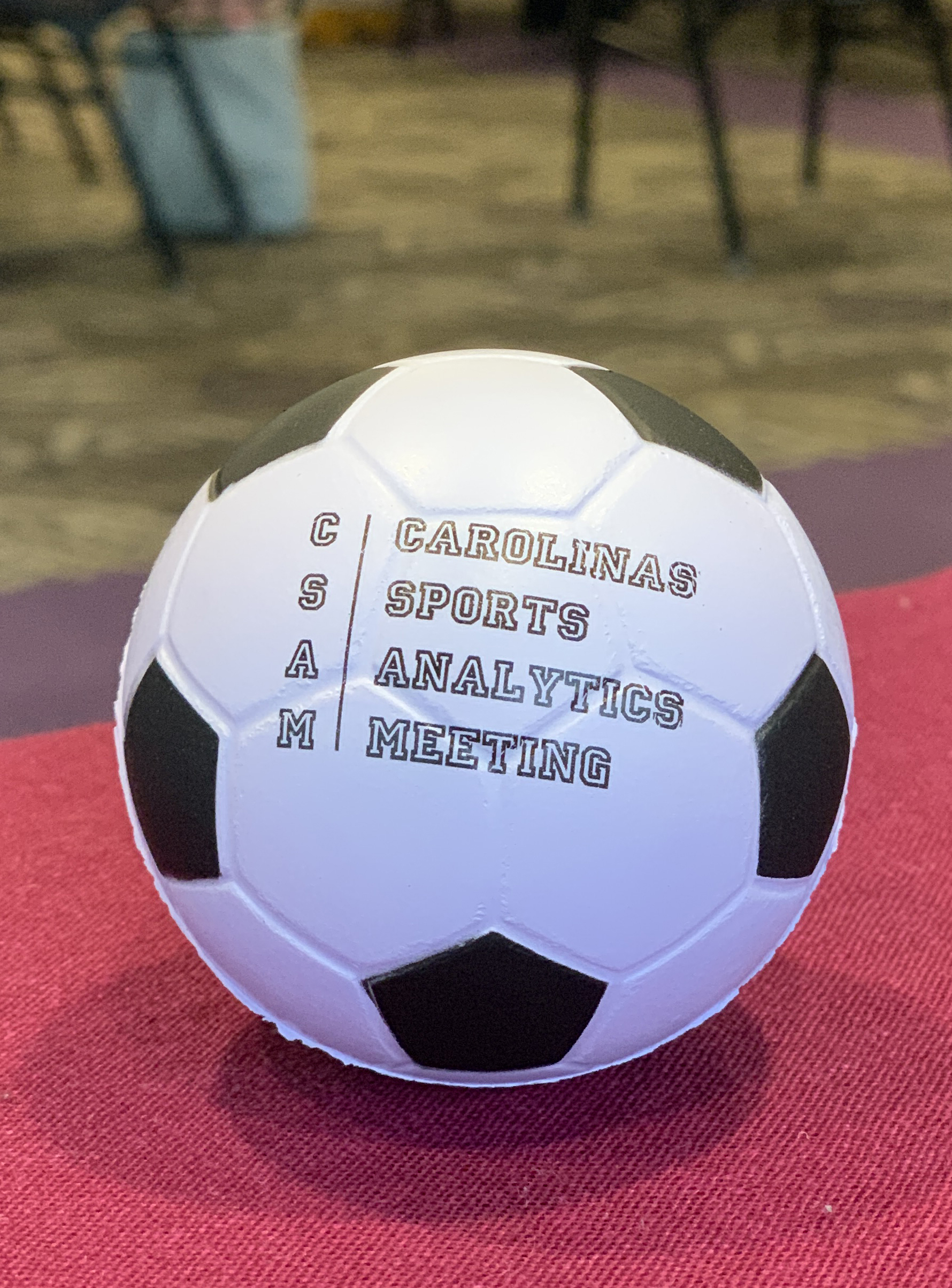 A soccer ball featuring the Carolinas Sports Analytics Meeting logo