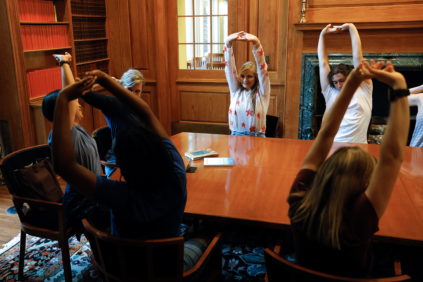 Students stretch with Furman professors Min-Ken Liao and Meghan Slinging in the James B. Duke Library's Haynsworth Room.