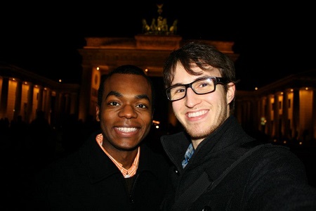 Black man and White man in front of gate