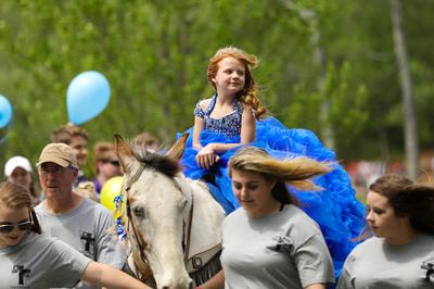 young girl with red hair and blue dress rides white horse, Anna Leigh