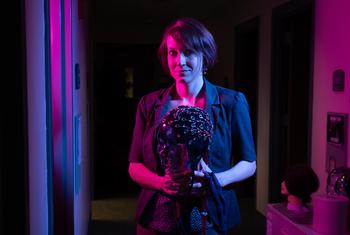 woman in dark room holding electrode cap, Erin Wamsley