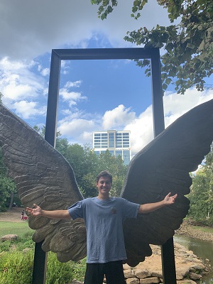 man posing in front of wings, Cameron Baird '24